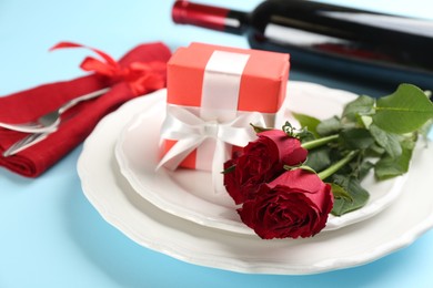 Photo of Beautiful table setting for Valentine's Day dinner on light blue background, closeup