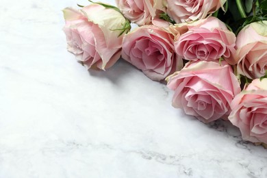 Photo of Beautiful bouquet of roses on white marble table, space for text. Happy birthday greetings