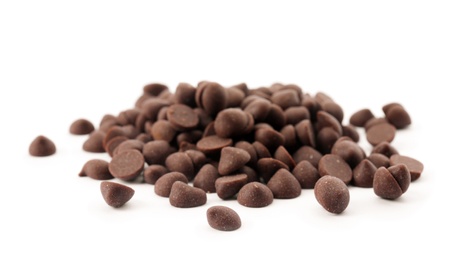 Pile of delicious dark chocolate chips on white background