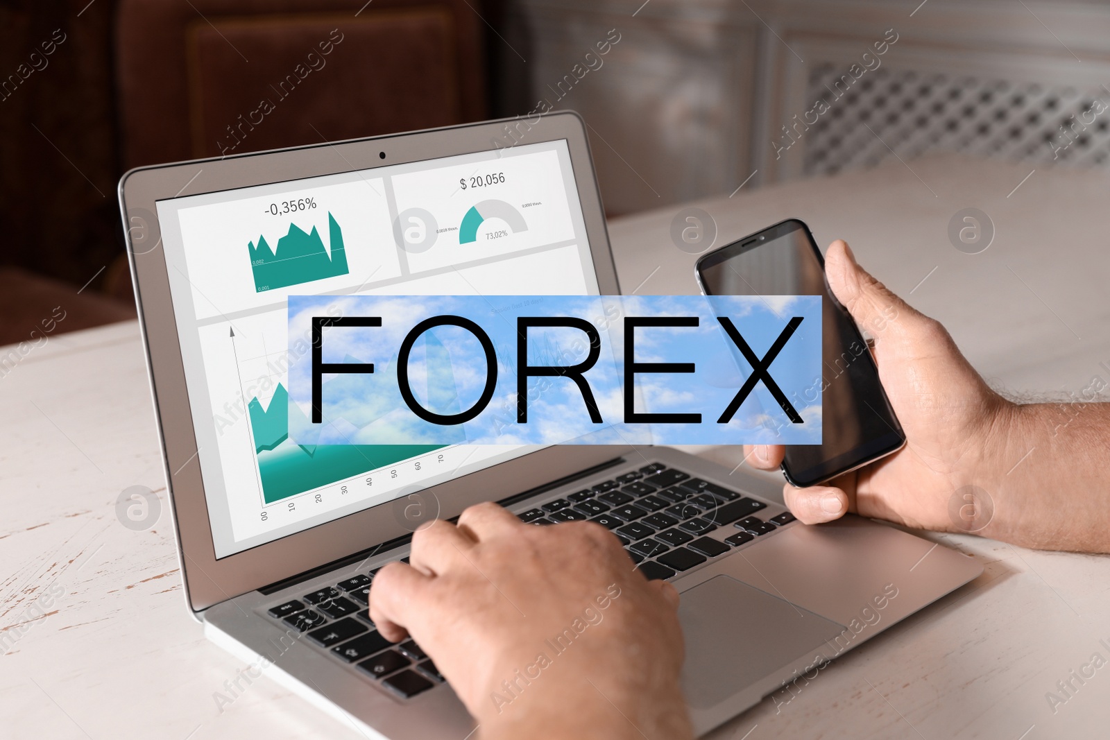 Image of Man working with smartphone and laptop at table indoors, closeup. Forex trading