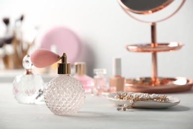 Photo of Perfume bottles and jewellery on dressing table