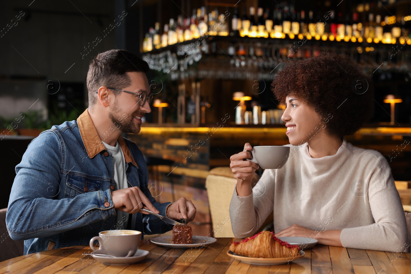 Photo of International relationships. Lovely couple having romantic date in cafe