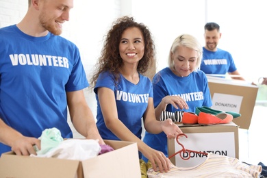 Team of volunteers collecting donations in boxes indoors