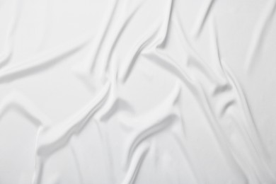 Photo of Texture of white crumpled silk fabric as background, top view