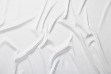 Texture of white crumpled silk fabric as background, top view