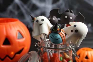 Different Halloween themed cake pops on dark background, closeup