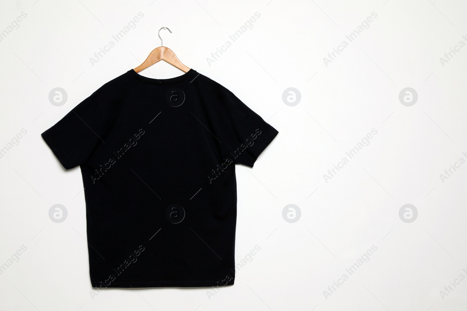 Photo of Hanger with blank t-shirt on white background. Mock up for design