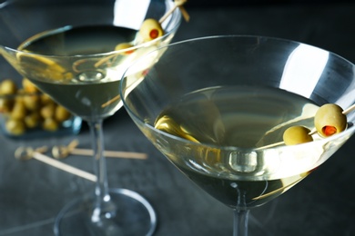 Glasses of Classic Dry Martini with olives on dark table, closeup