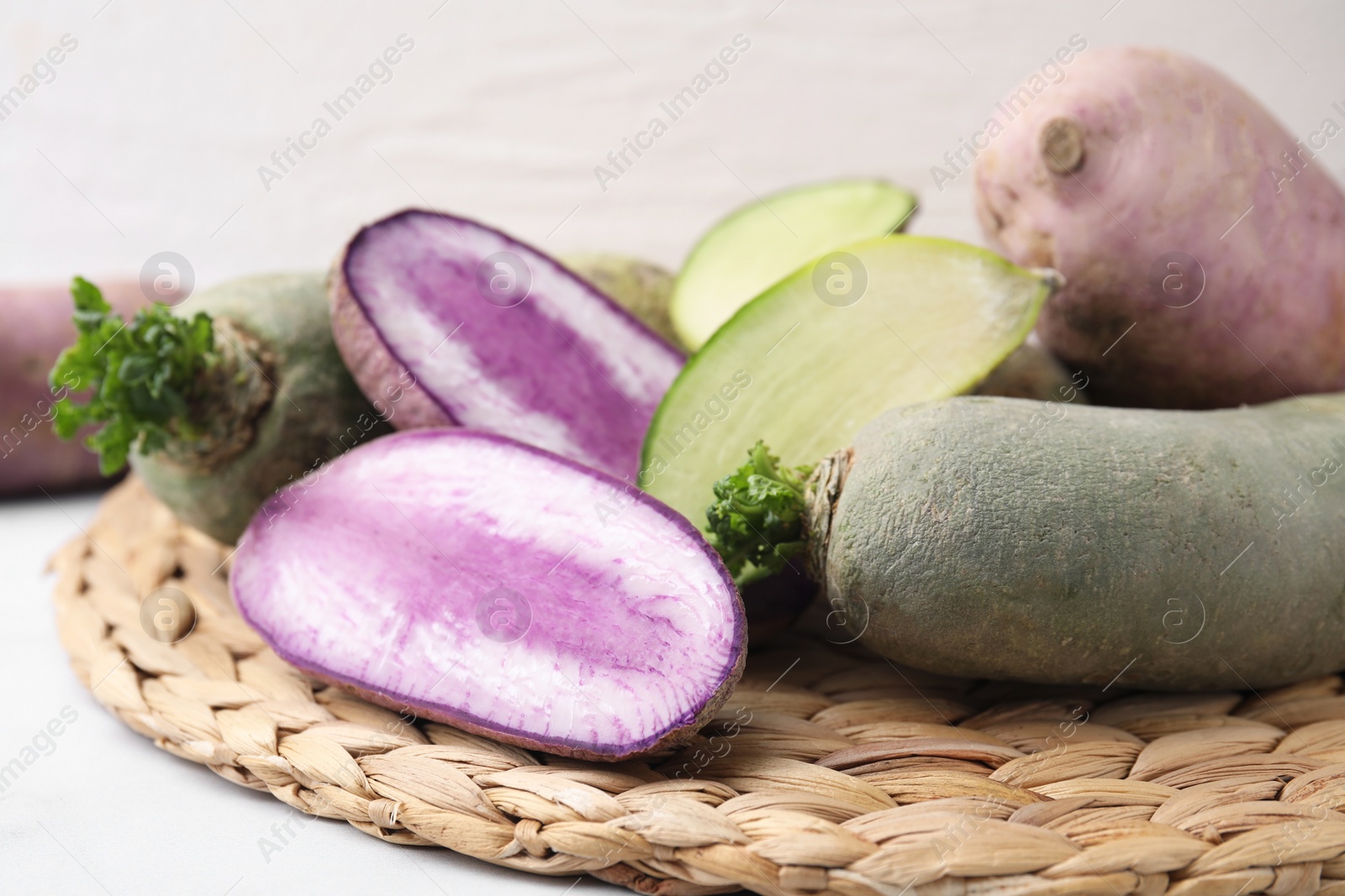 Photo of Green and purple daikon radishes on table, closeup