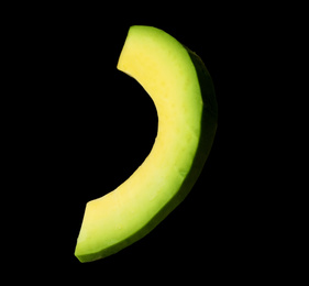 Photo of Slice of fresh avocado on black background