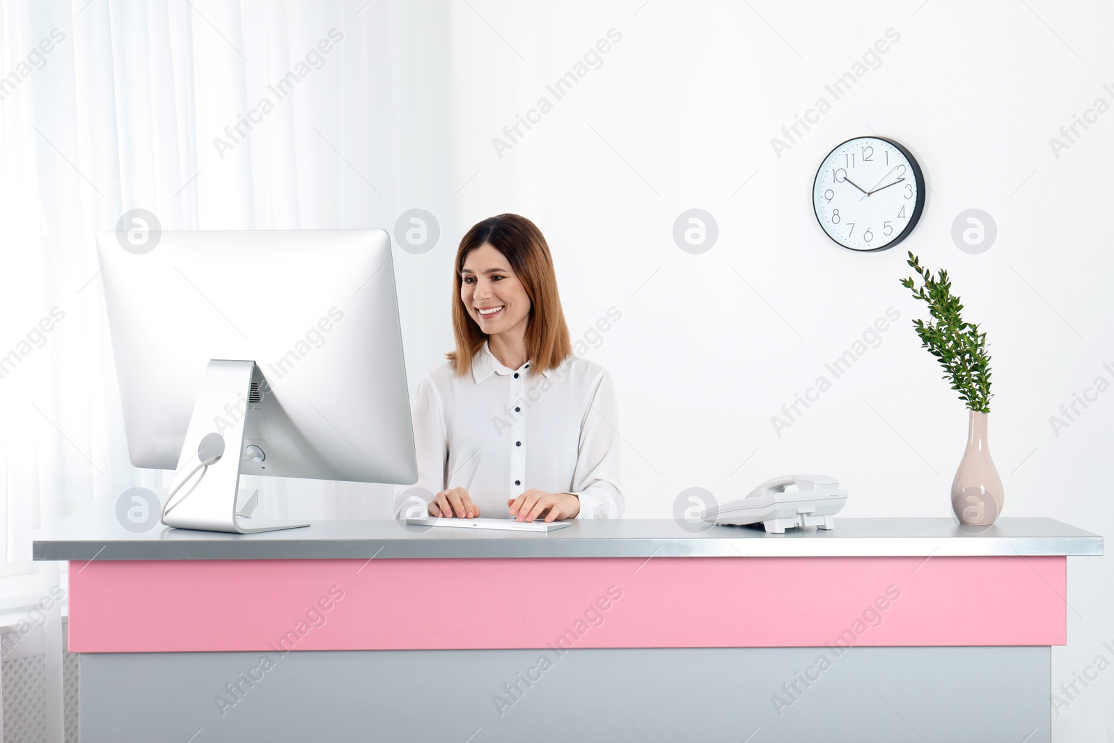 Photo of Beautiful woman working at reception desk in beauty salon