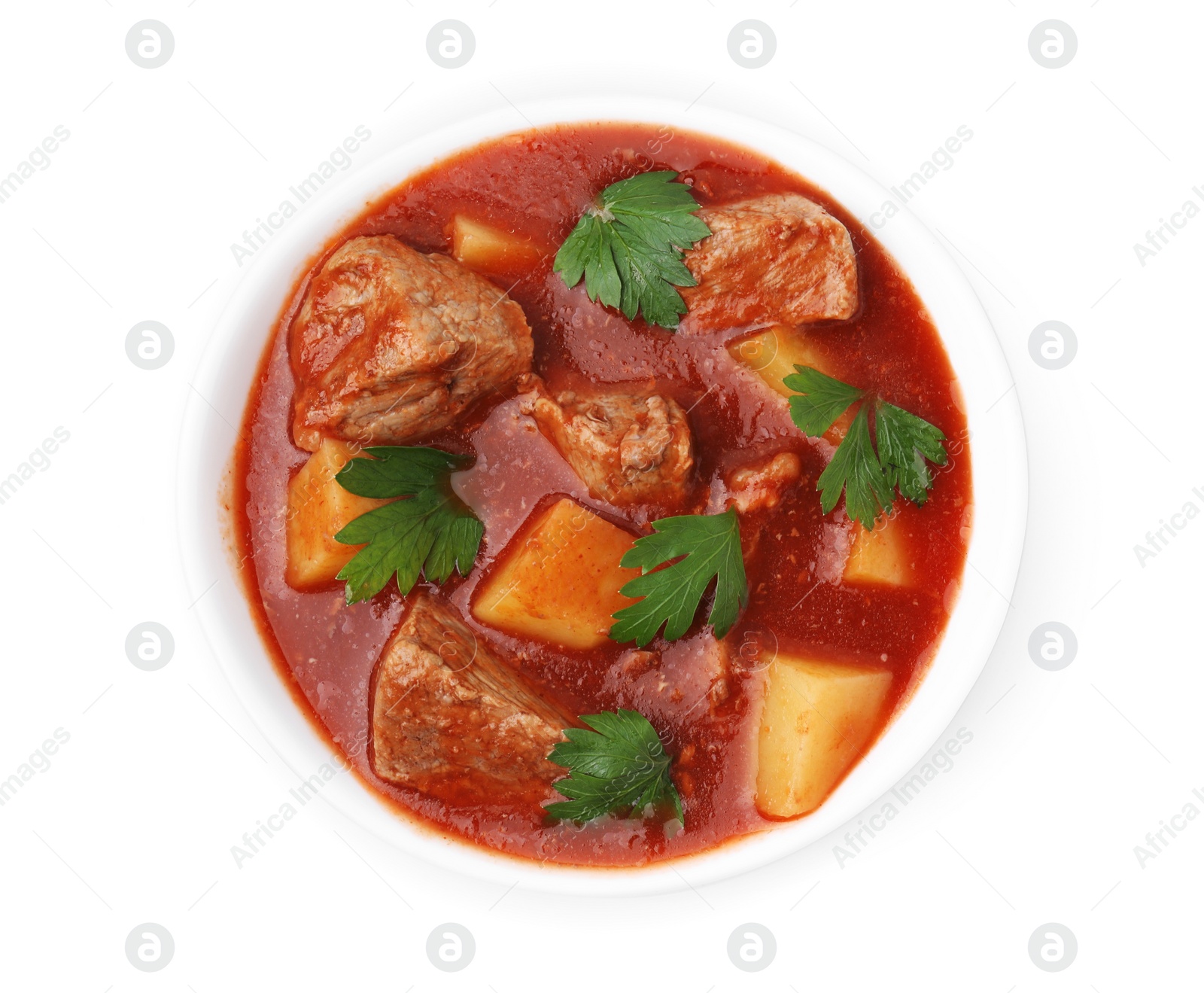 Photo of Delicious goulash in bowl isolated on white, top view