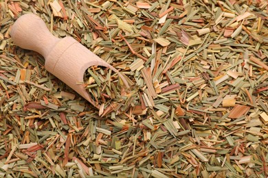 Wooden scoop and aromatic dried lemongrass, top view. Space for text