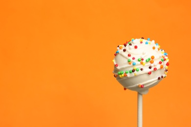 Photo of Bright delicious cake pop on color background. Space for text