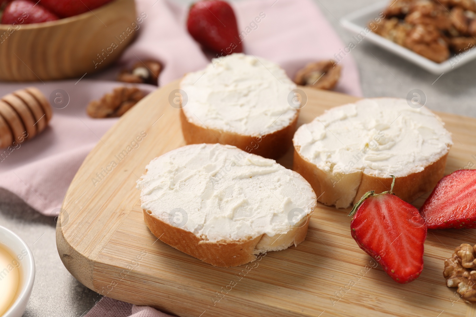 Photo of Delicious bruschettas with ricotta cheese, strawberries and walnuts on table, closeup