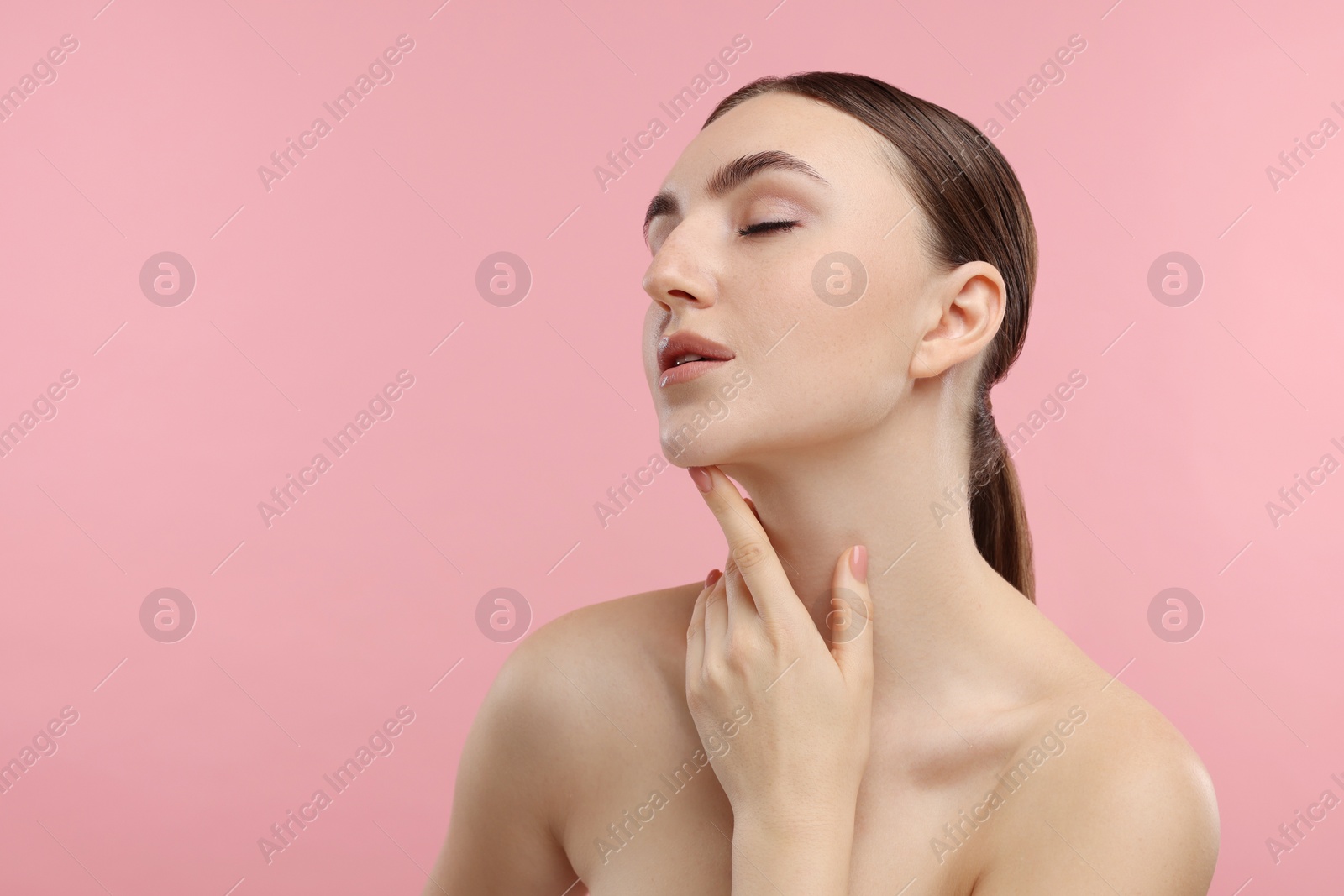 Photo of Beautiful woman touching her chin on pink background. Space for text