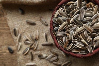 Organic sunflower seeds on wooden table, flat lay. Space for text