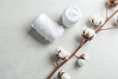 Photo of Flat lay composition with cotton rolls and flowers on grey stone background