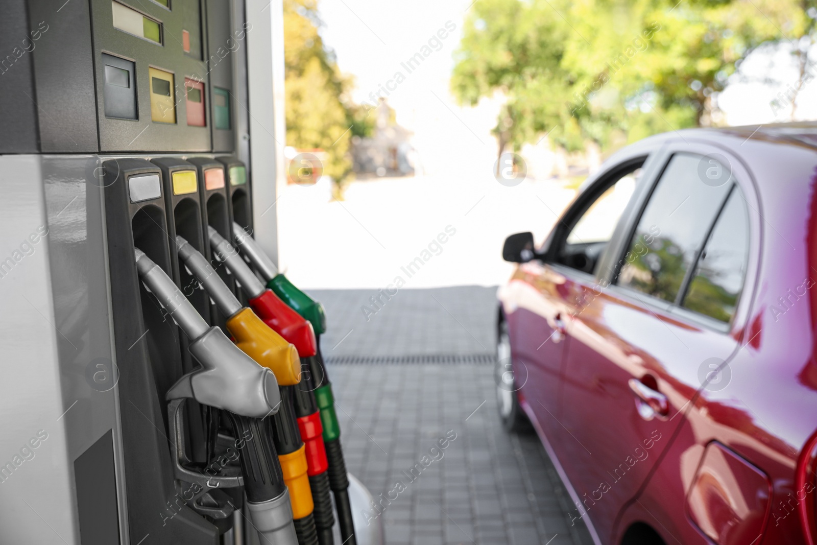 Photo of Red car at modern gas station on sunny day