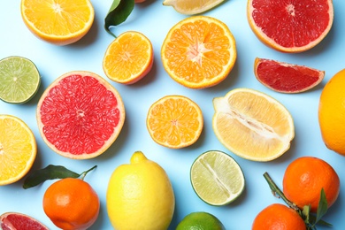 Different citrus fruits on color background, top view