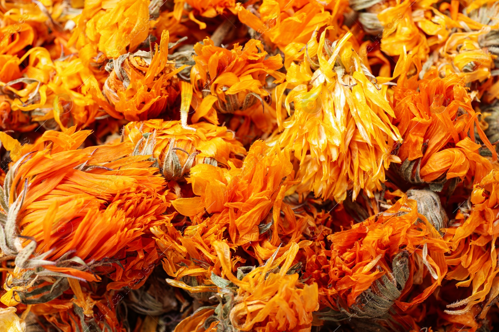 Photo of Pile of dry calendula flowers as background, closeup