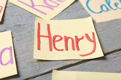 Photo of Paper sheet with baby name Henry on grey wooden table, closeup