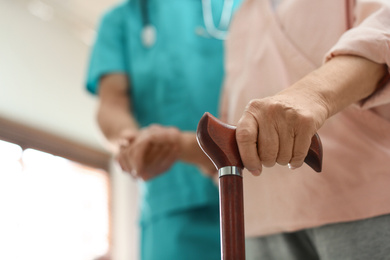 Photo of Medical worker taking care of elderly woman in geriatric hospice, closeup