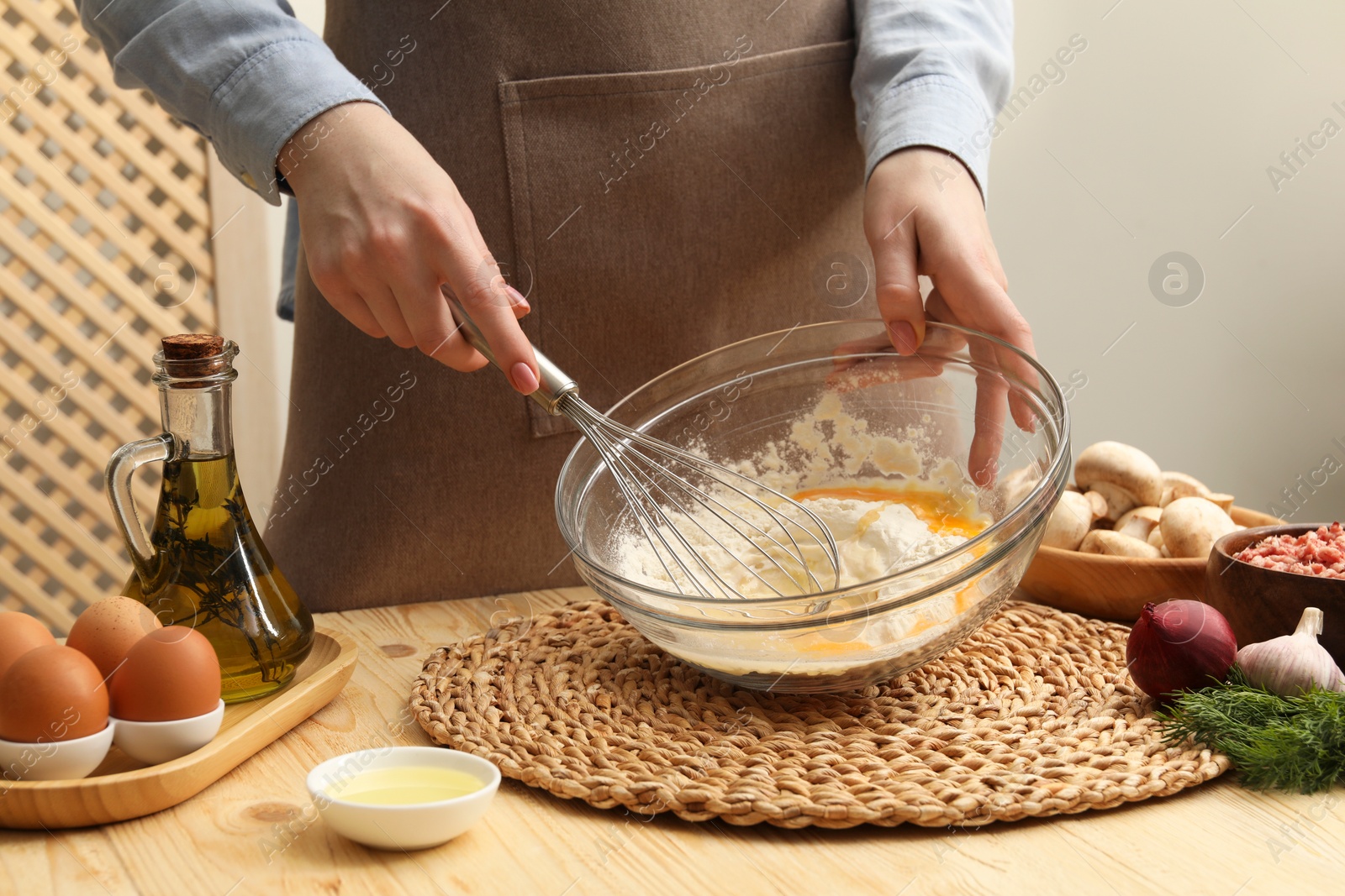 Photo of Woman making dough at wooden table, closeup