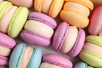 Photo of Many delicious colorful macarons on white background, top view