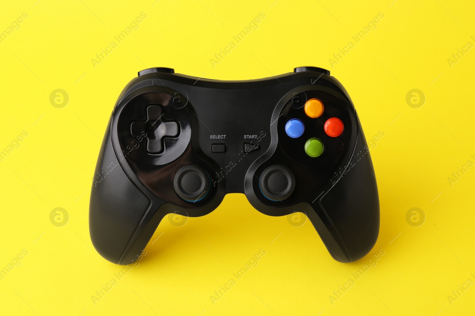 Photo of One wireless game controller on yellow background