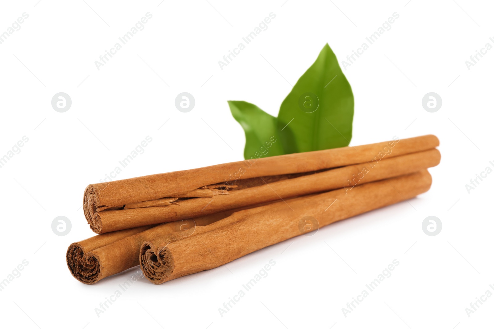 Photo of Aromatic dry cinnamon sticks and green leaves on white background