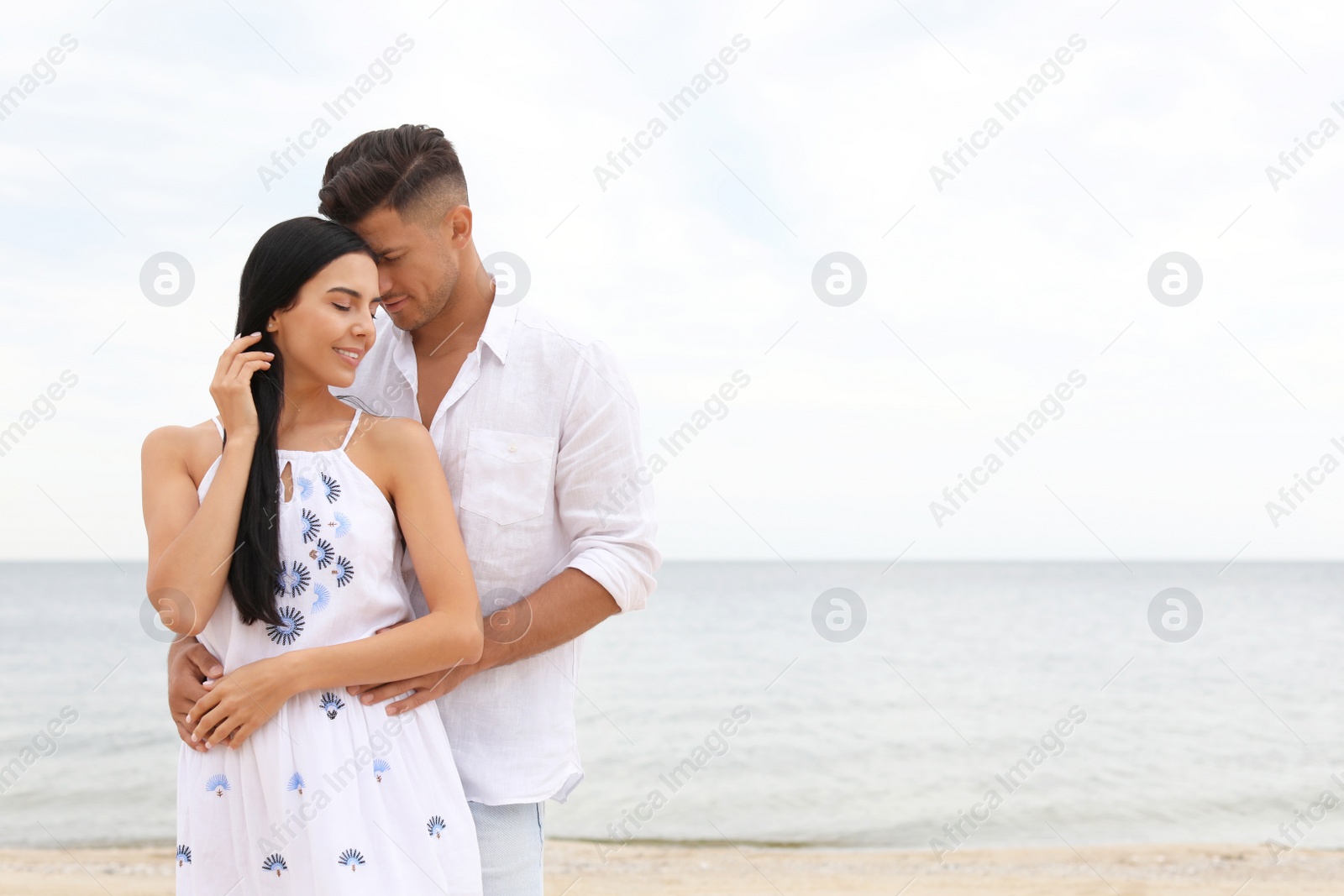 Photo of Lovely couple spending time together on beach. Space for text