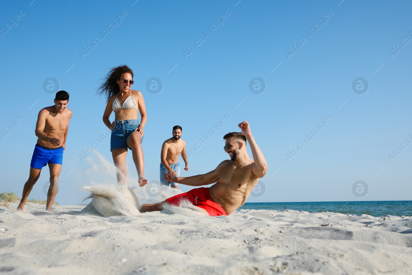 Photo of Group of friends playing football on beach