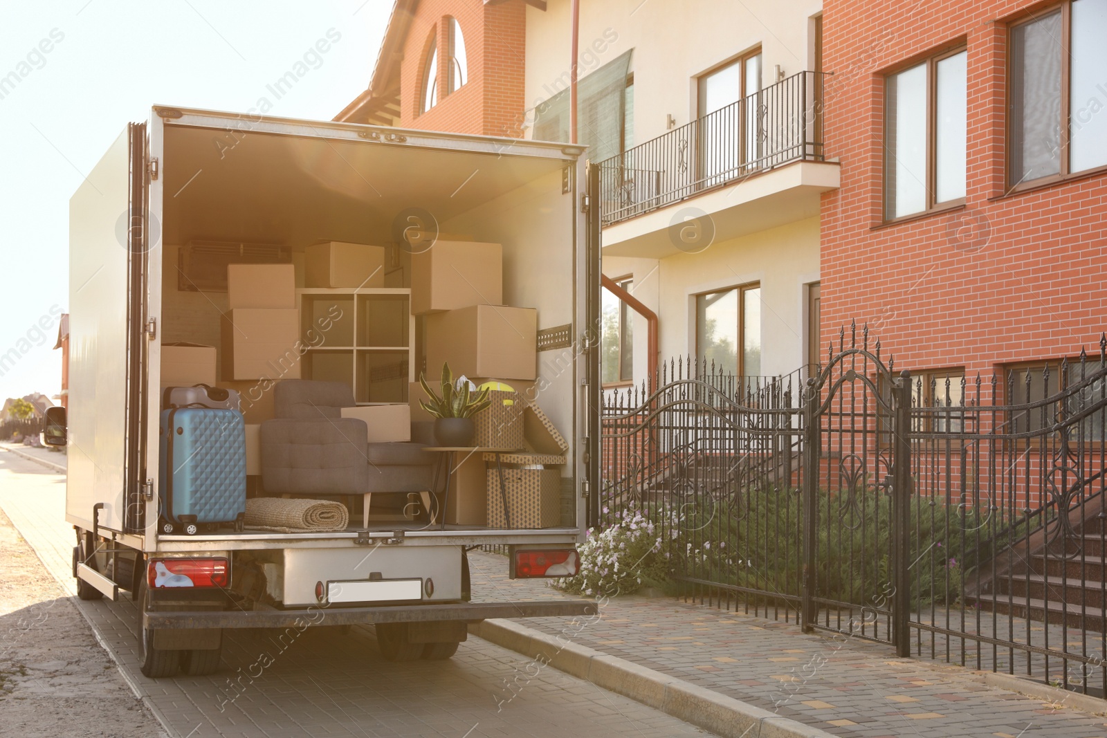 Photo of Van full of moving boxes and furniture near house