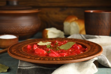 Stylish brown clay plate with Ukrainian borsch served  on wooden table