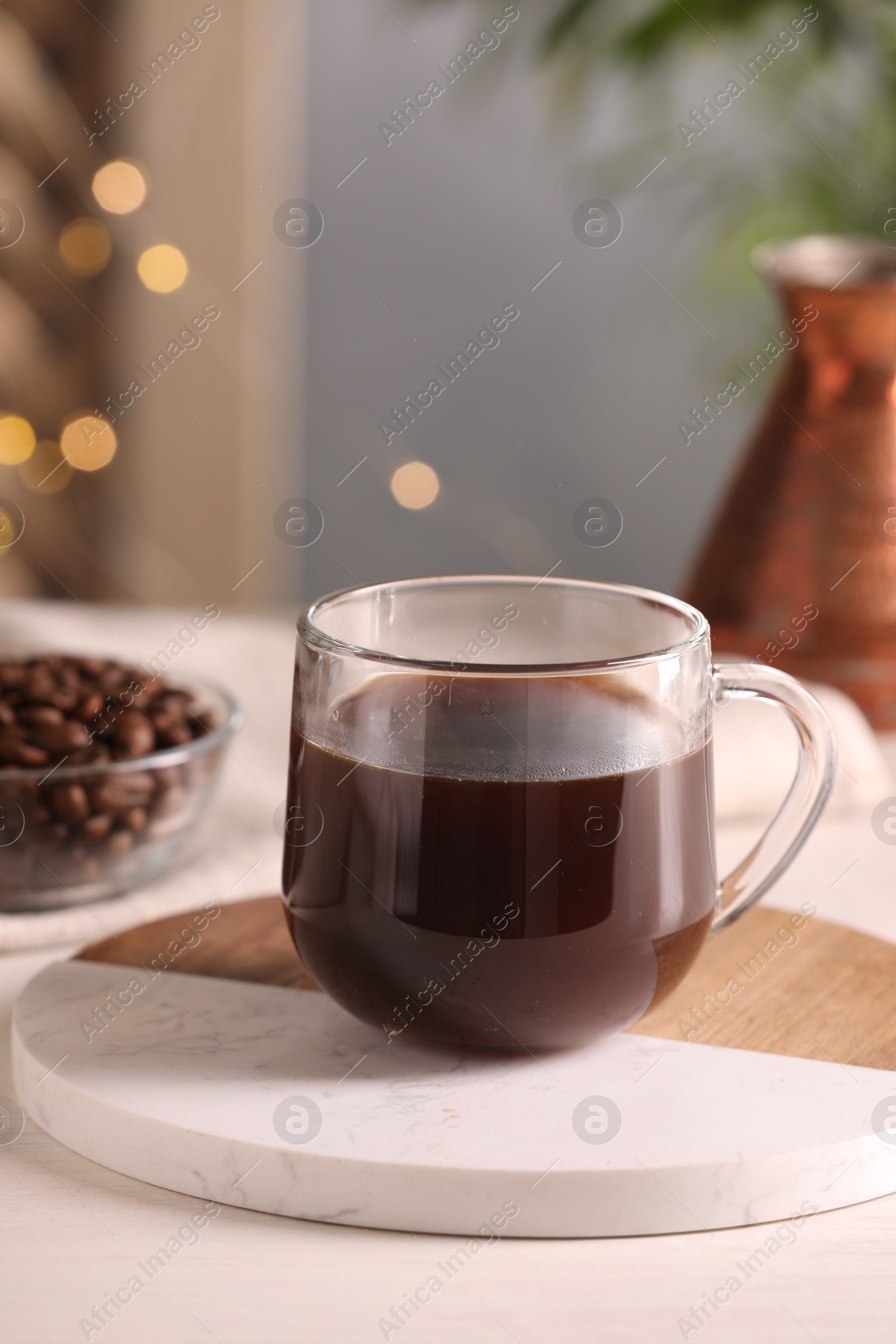 Photo of Delicious coffee in cup on white wooden table