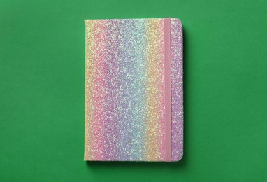 Photo of New stylish planner with hard cover on green background, top view