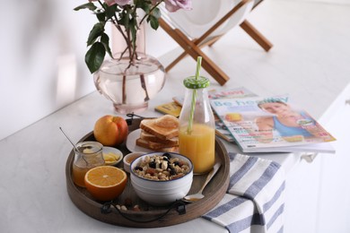 Tray with tasty breakfast on white table. Space for text