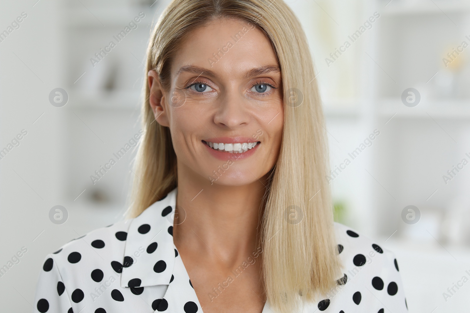 Photo of Portrait of beautiful woman in stylish clothes indoors. Confident lady with blonde hair looking into camera