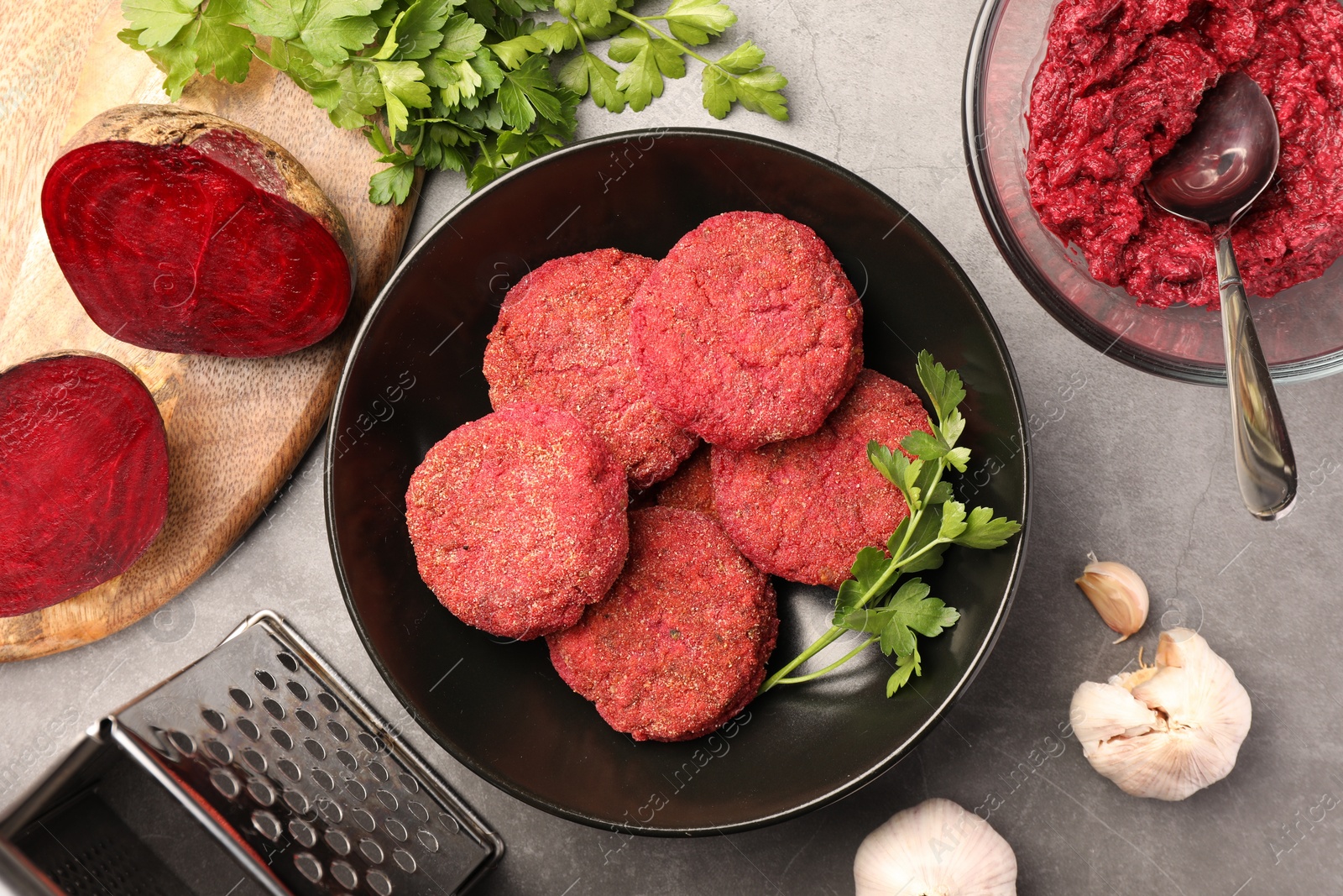 Photo of Delicious beetroot vegan cutlets and ingredients on light gray table, flat lay