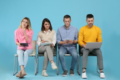 Photo of People waiting for job interview on light blue background