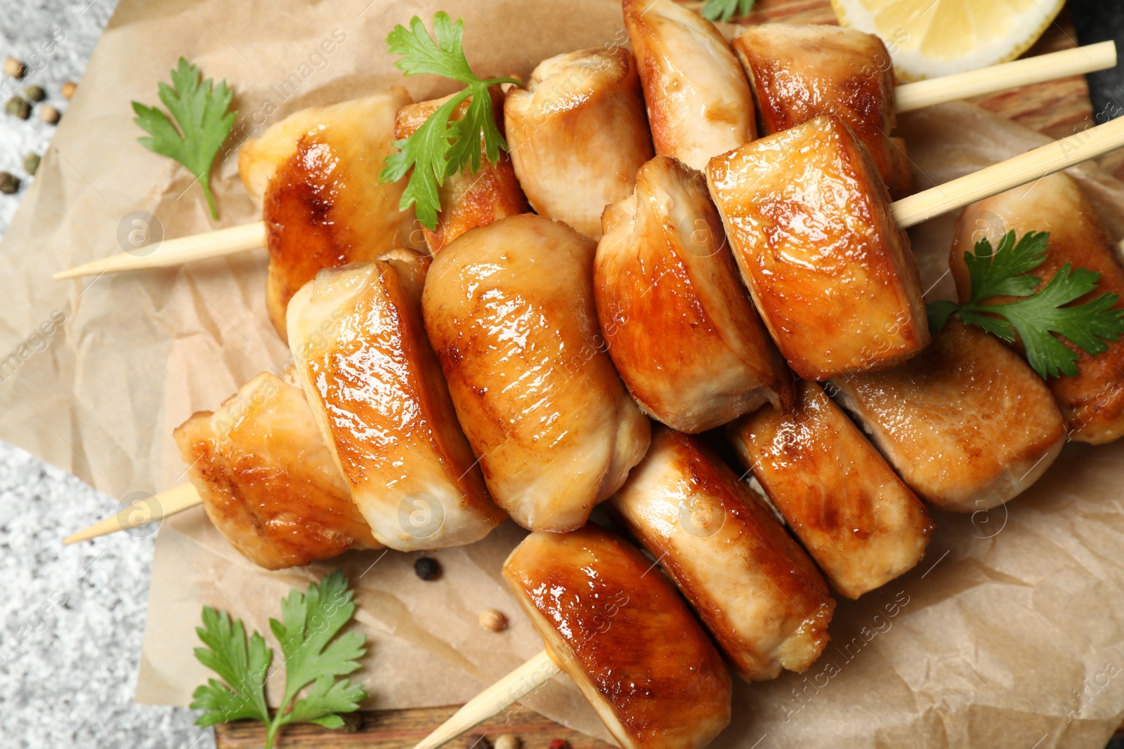 Photo of Delicious chicken shish kebabs with parsley on grey background, closeup
