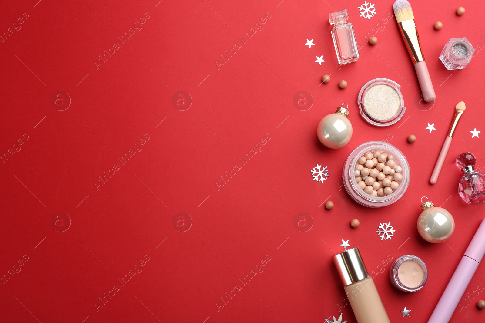 Photo of Flat lay composition with decorative cosmetic products on red background, space for text. Winter care