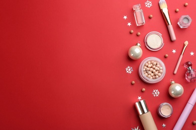 Flat lay composition with decorative cosmetic products on red background, space for text. Winter care