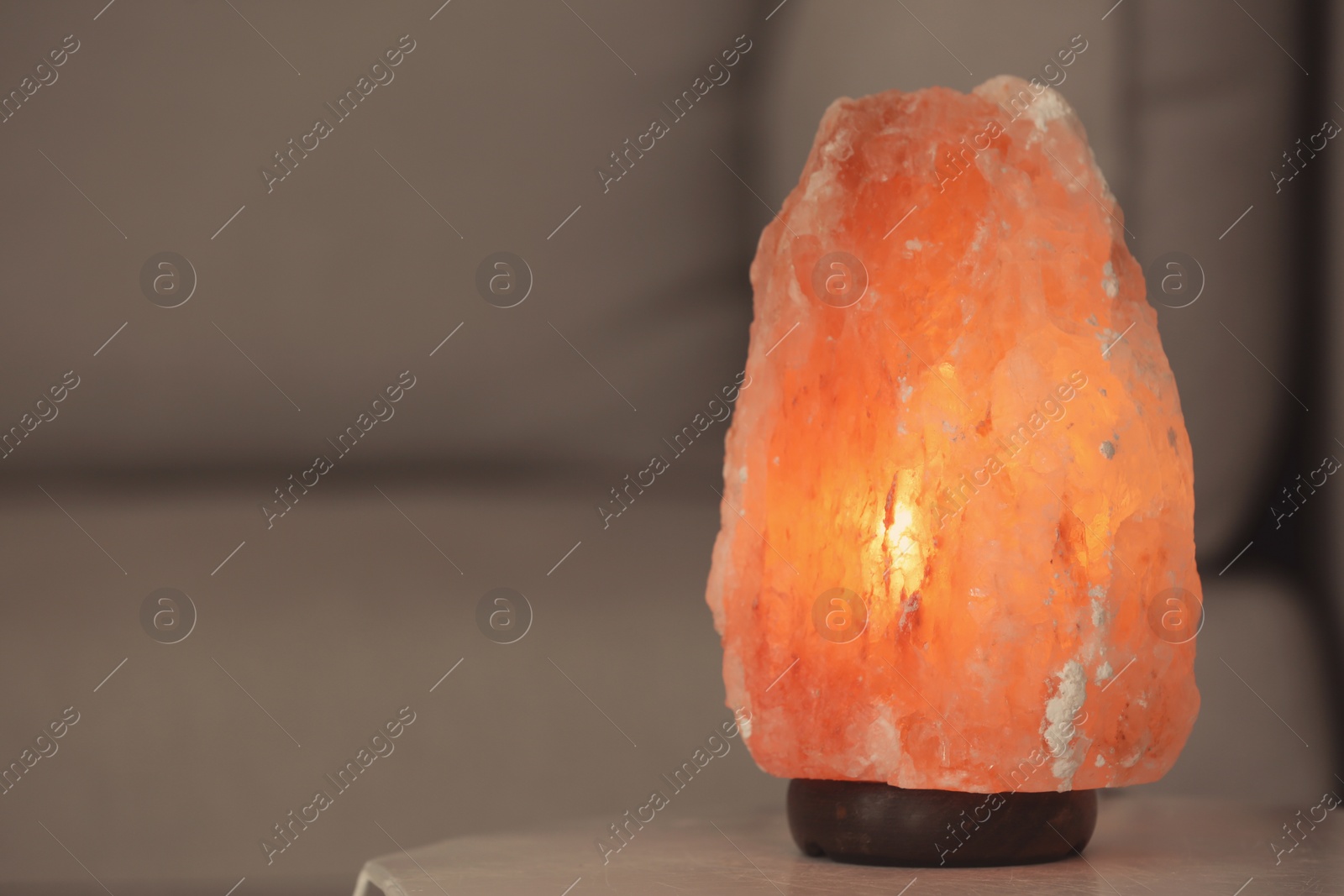 Photo of Himalayan salt lamp on table against blurred background