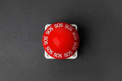 Image of Red SOS button on dark grey background. Space for text