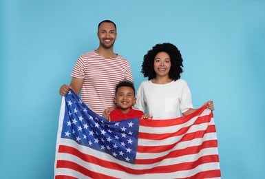 4th of July - Independence Day of USA. Happy family with American flag on light blue background