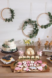 Photo of Baby shower party. Different delicious treats on wooden table indoors