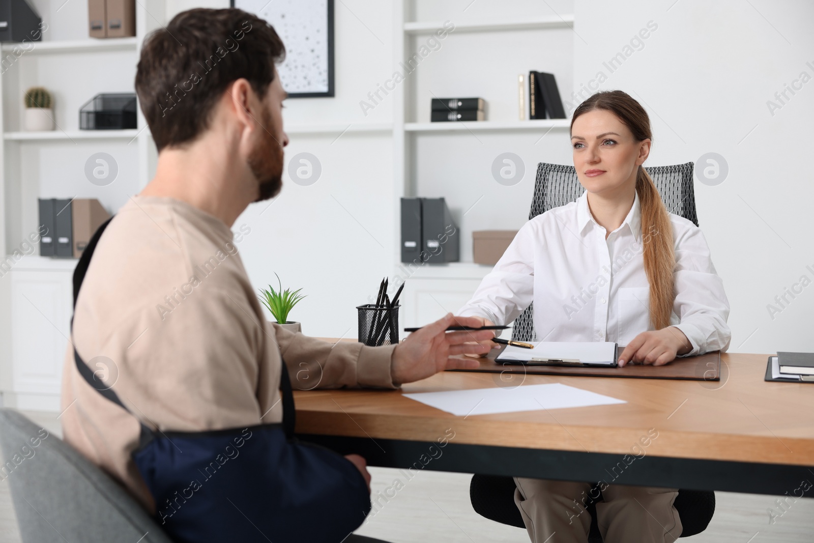 Photo of Injured man having meeting with lawyer in office