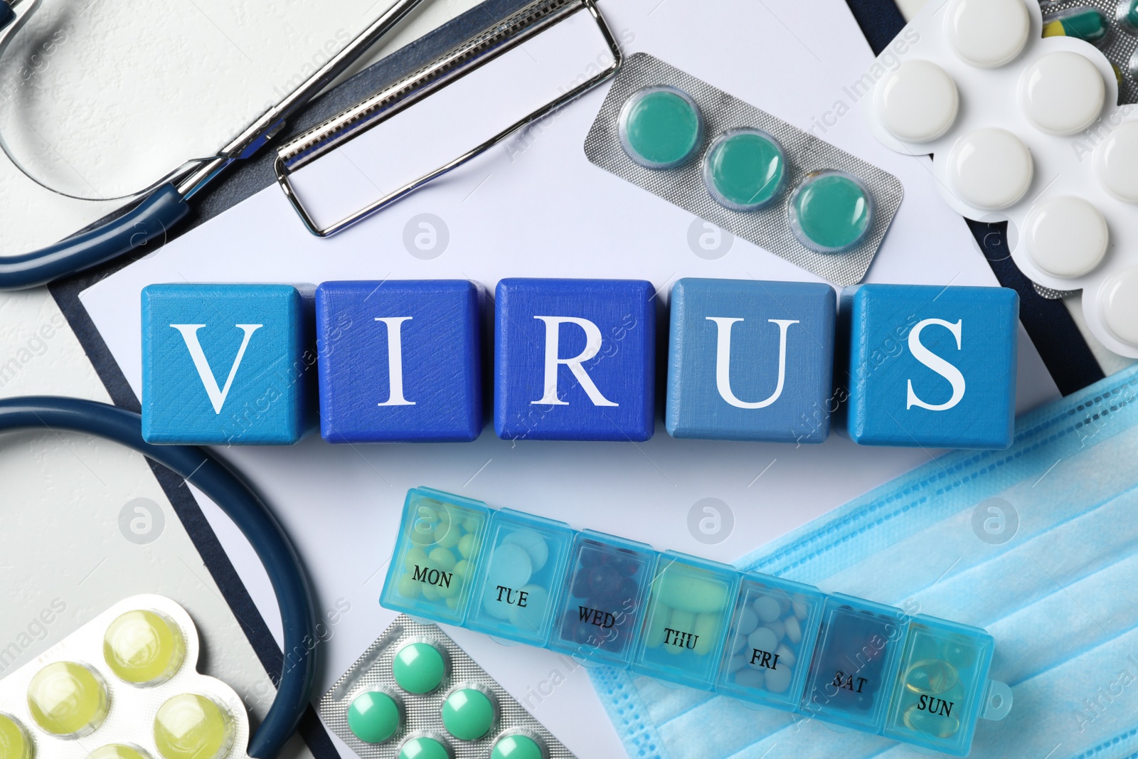 Photo of Cubes with word VIRUS and medicines on white background, flat lay